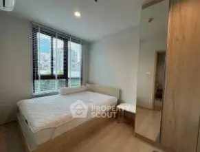 Modern bedroom with large window and wooden furniture in a stylish apartment.