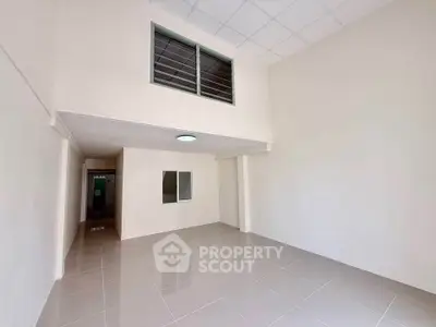 Spacious interior with high ceiling and tiled flooring, perfect for customization.