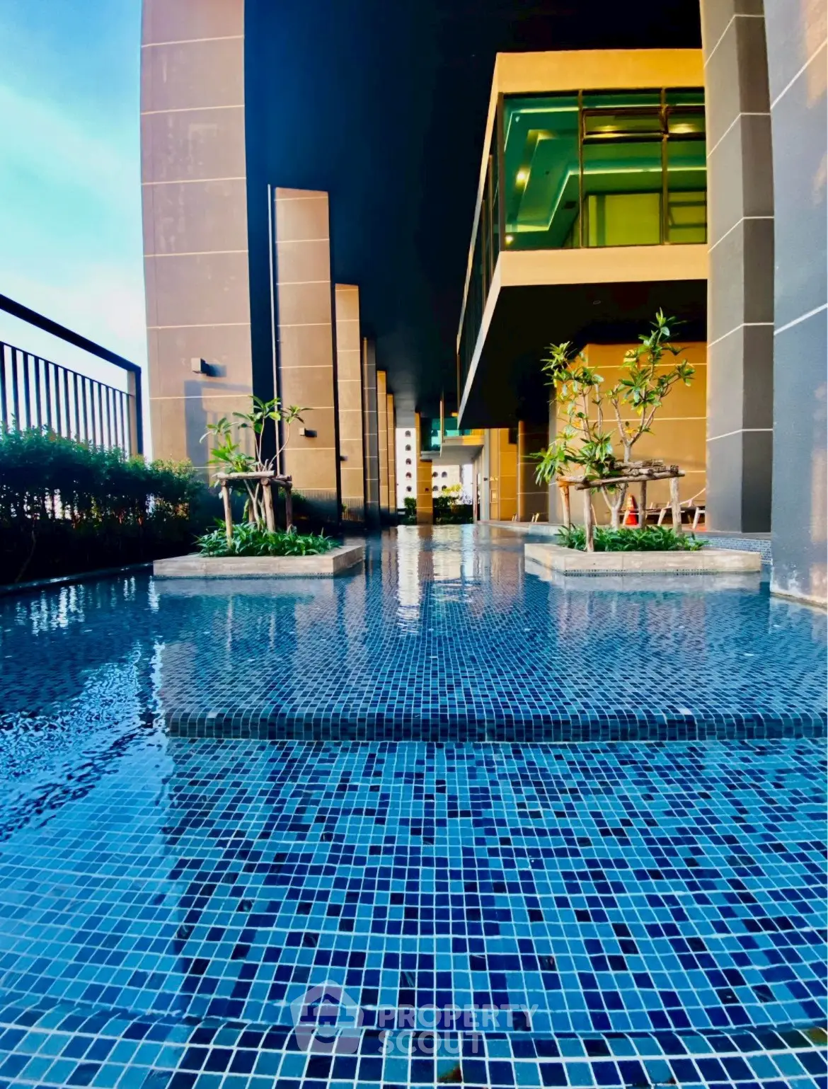 Luxurious modern building with stunning poolside view and elegant architectural design.