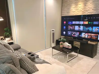 Modern living room with stylish decor and large flat-screen TV, perfect for entertainment.