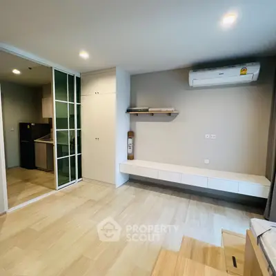 Modern living room with built-in storage and air conditioning in a stylish apartment.