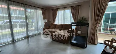 Spacious living room with large windows and modern furnishings, perfect for relaxation.