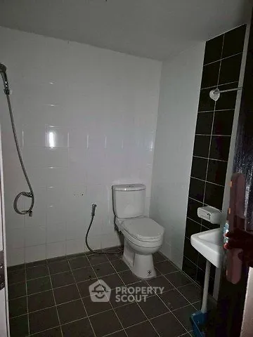 Compact bathroom with modern fixtures and tiled walls, featuring a shower and toilet.