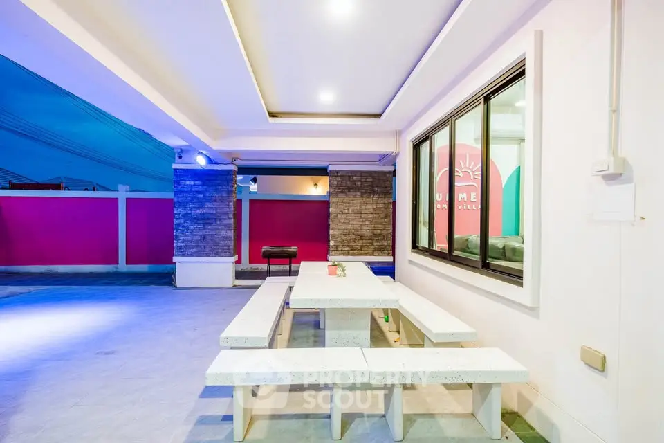 Modern outdoor patio with stylish seating and vibrant lighting, perfect for entertaining.