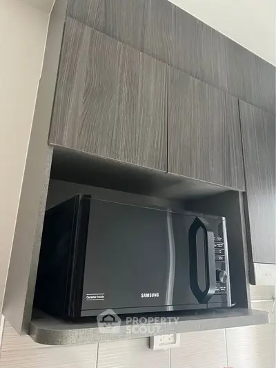 Modern kitchen with sleek cabinetry and built-in Samsung microwave oven.