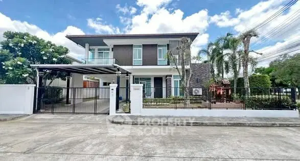 Stunning modern two-story house with gated entrance and lush landscaping