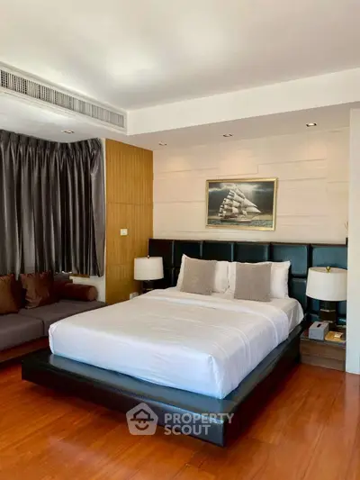 Luxurious bedroom with elegant decor and hardwood flooring in modern apartment.