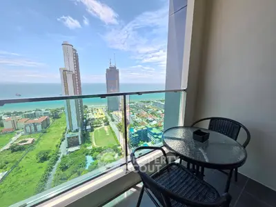 Stunning high-rise balcony with ocean view and modern outdoor seating.