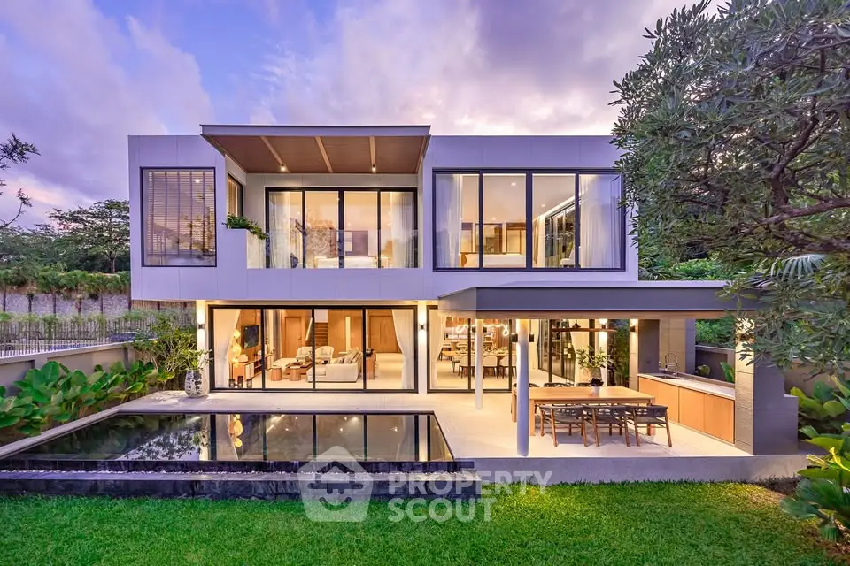 Luxurious modern home with large windows, pool, and lush garden, perfect for elegant living.