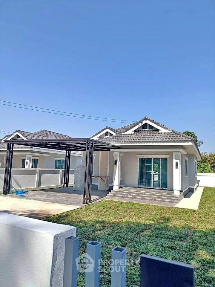 Charming single-story house with modern design and spacious yard under clear blue sky.