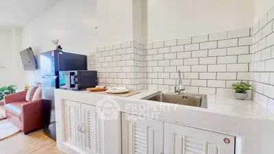 Modern kitchen with sleek white cabinetry and stylish subway tile backsplash in a cozy apartment.