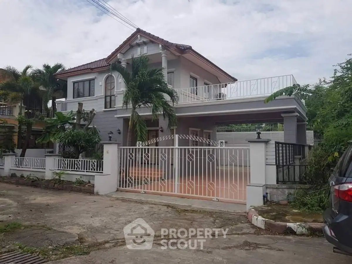 Charming two-story house with spacious balcony and lush greenery in a serene neighborhood.