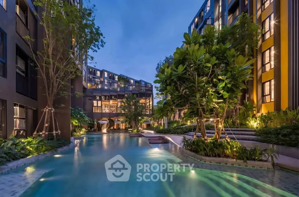 Luxurious condominium with stunning pool and lush garden view at twilight.