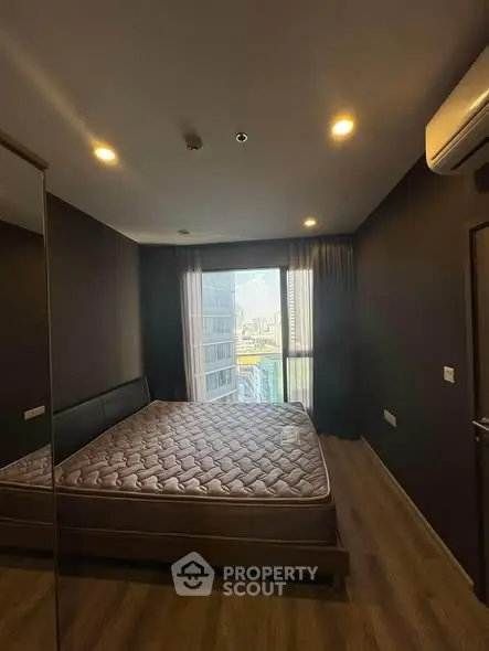Modern bedroom with city view, featuring a comfortable bed and sleek design in a high-rise apartment.