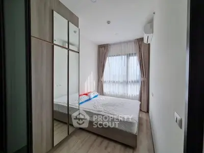 Modern bedroom with large mirrored wardrobe and natural light