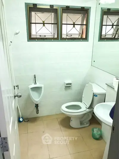 Spacious bathroom with modern fixtures and natural light from windows.