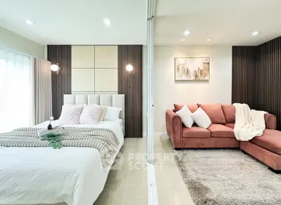 Luxurious bedroom with stylish decor and cozy seating area, perfect for relaxation.
