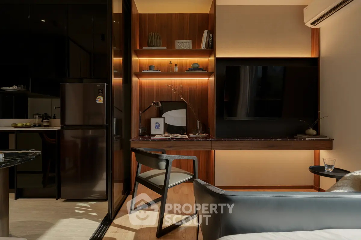 Modern living room with sleek furniture and ambient lighting, featuring a wall-mounted TV and stylish shelving.