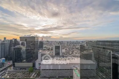 Stunning cityscape view from a high-rise building showcasing urban skyline and sunset.