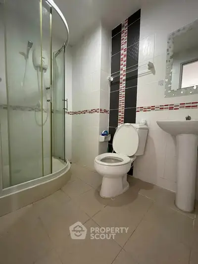 Modern bathroom with glass shower and stylish tile accents in a contemporary home.