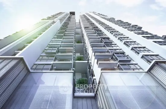 Modern high-rise building with sleek architecture and glass balconies under a clear sky.