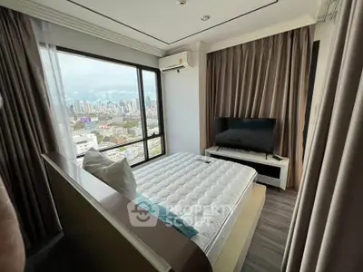 Modern bedroom with city view, featuring large window and sleek furnishings.