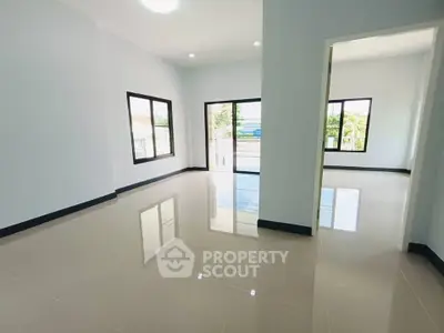 Spacious modern living room with large windows and glossy tiled floors