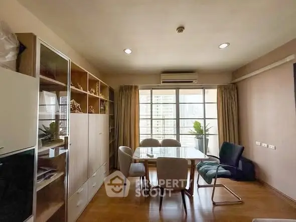 Spacious dining area with natural light and modern furnishings in a high-rise apartment.