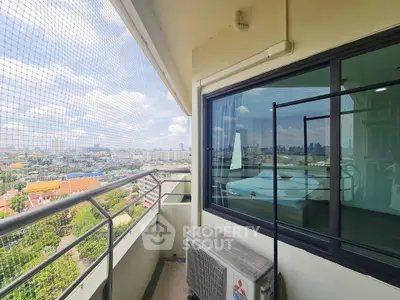 Spacious balcony with city view and air conditioning unit in modern apartment