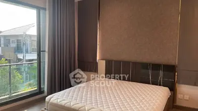 Modern bedroom with large window and stylish decor in a contemporary apartment.