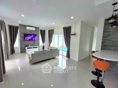 Modern living room with sleek design and pool view, featuring stylish furniture and elegant lighting.