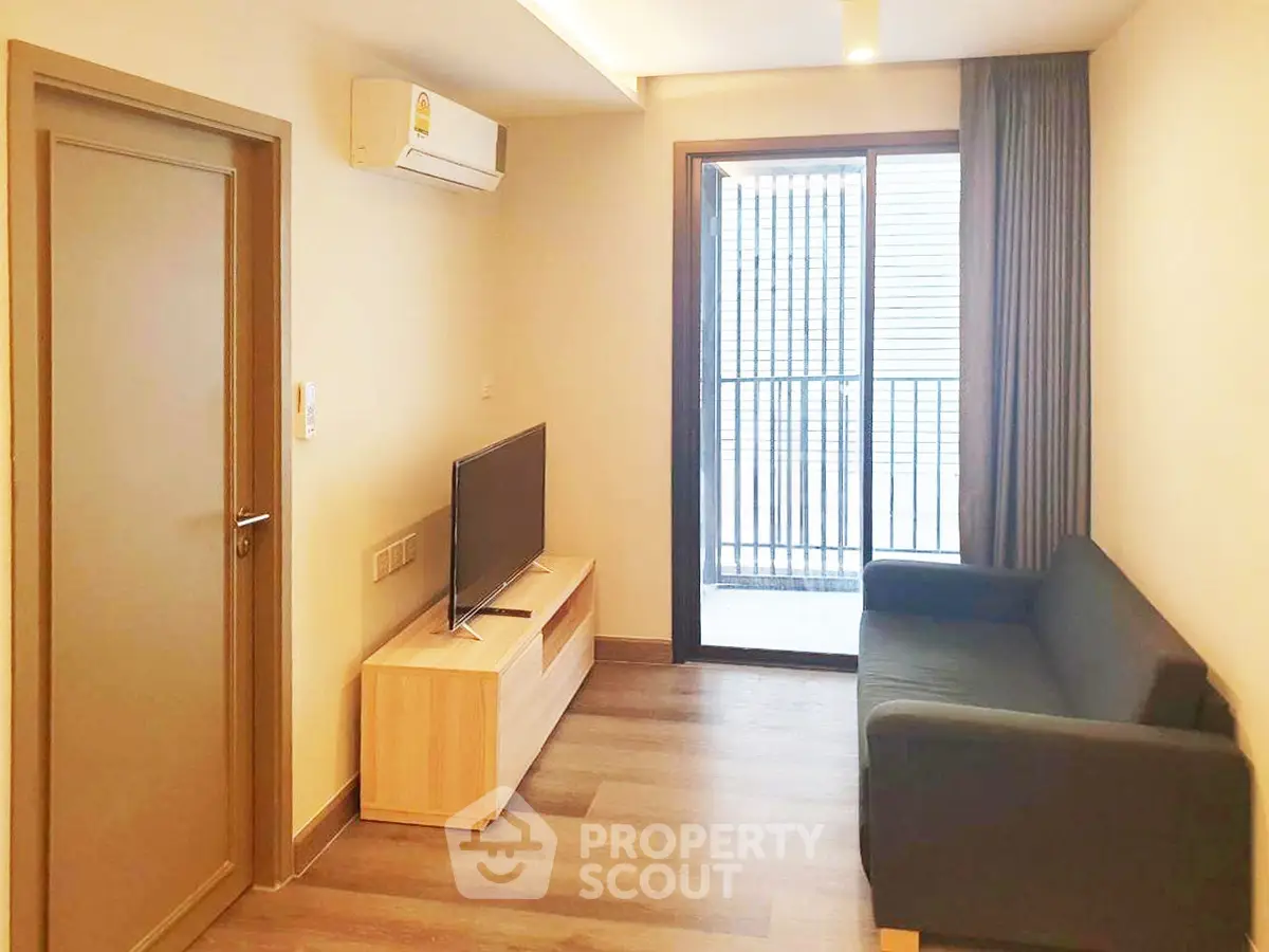 Modern living room with sleek design, featuring a cozy sofa, flat-screen TV, and balcony access for urban living.