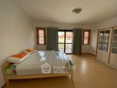 Spacious bedroom with large windows and wooden flooring