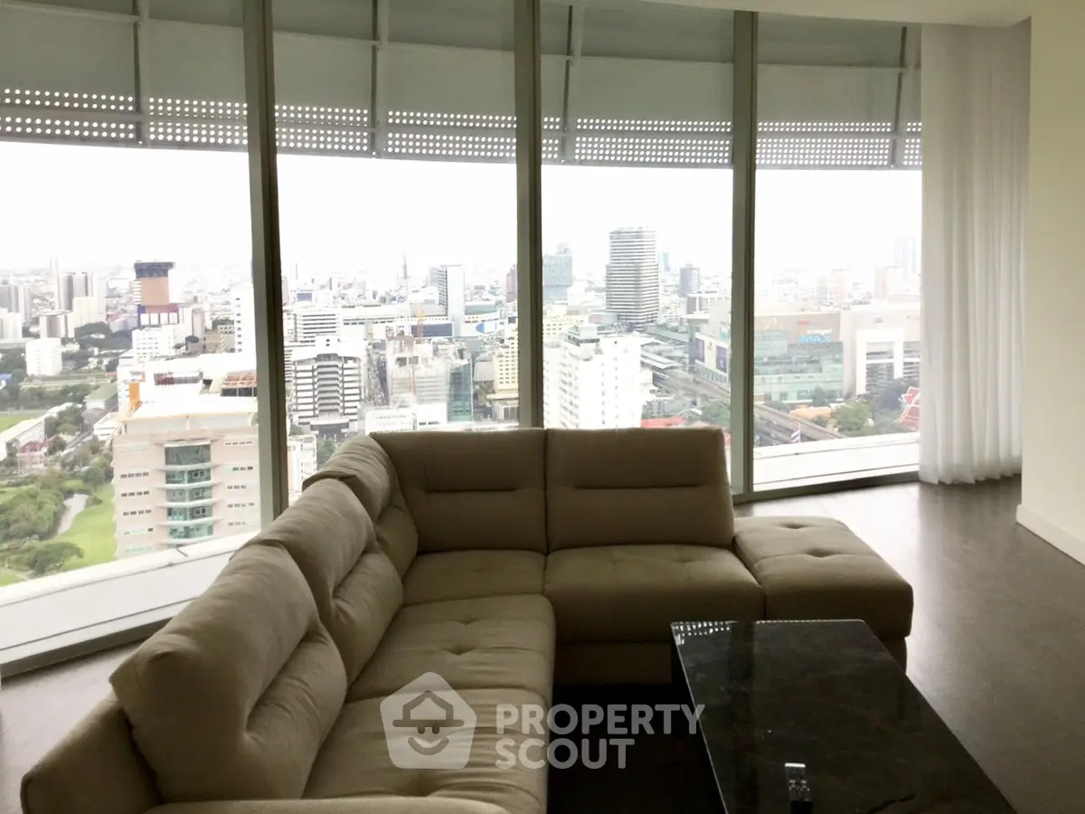 Luxurious living room with panoramic city view from floor-to-ceiling windows and modern furniture.