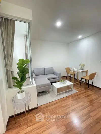 Modern living room with cozy seating and dining area, featuring elegant wooden flooring and stylish decor.
