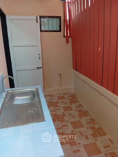 Compact outdoor kitchen area with tiled countertop and sink, ideal for small spaces.