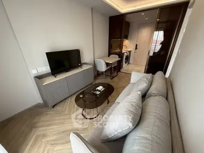 Modern living room with sleek furniture and open kitchen layout in a stylish apartment.