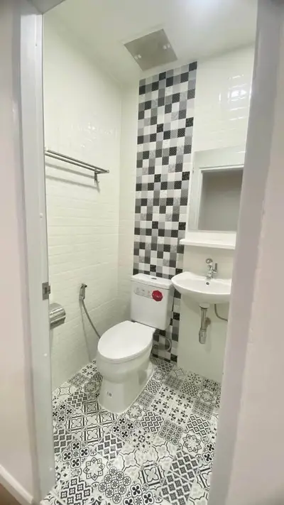 Modern bathroom with stylish black and white tile design and compact layout.