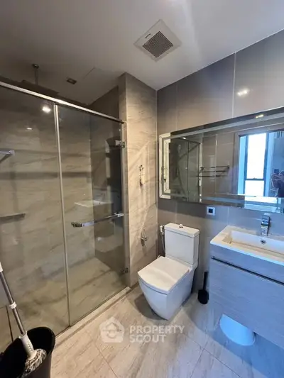 Modern bathroom with glass shower and sleek fixtures in a contemporary apartment.