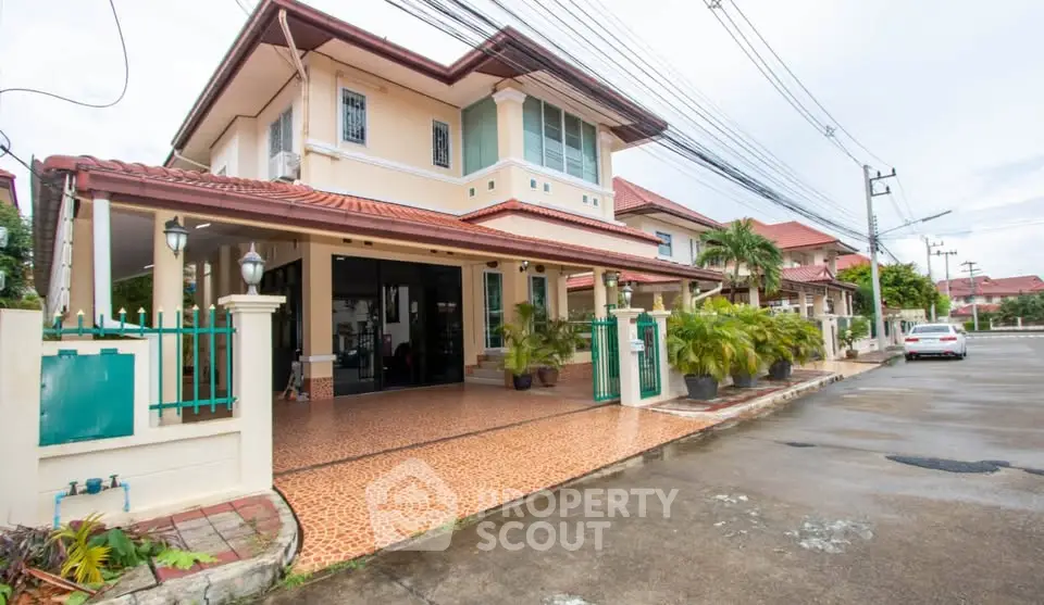 Spacious two-story house with tiled driveway and lush greenery in a serene neighborhood.