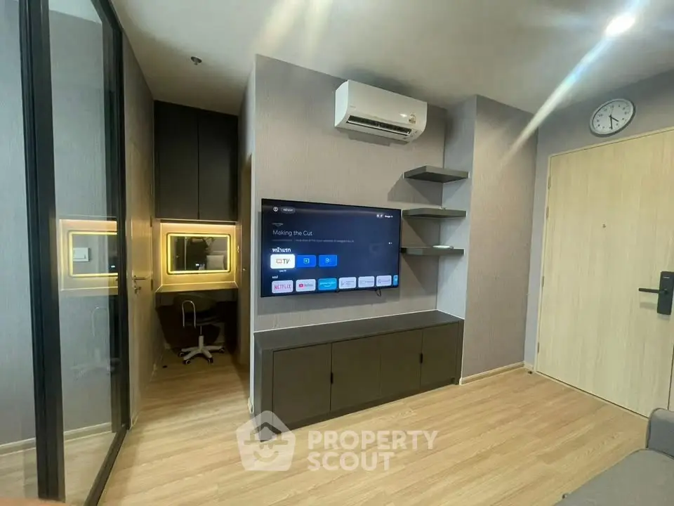 Modern living room with wall-mounted TV and air conditioning in a stylish apartment.