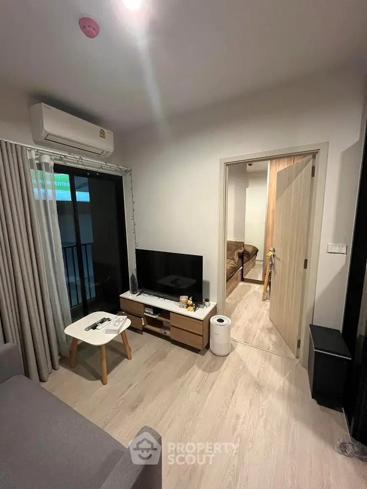 Cozy living room with modern decor, featuring a TV unit and air conditioning, perfect for relaxation.