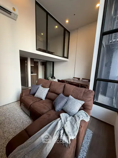Modern living room with high ceilings and stylish decor in a contemporary apartment.