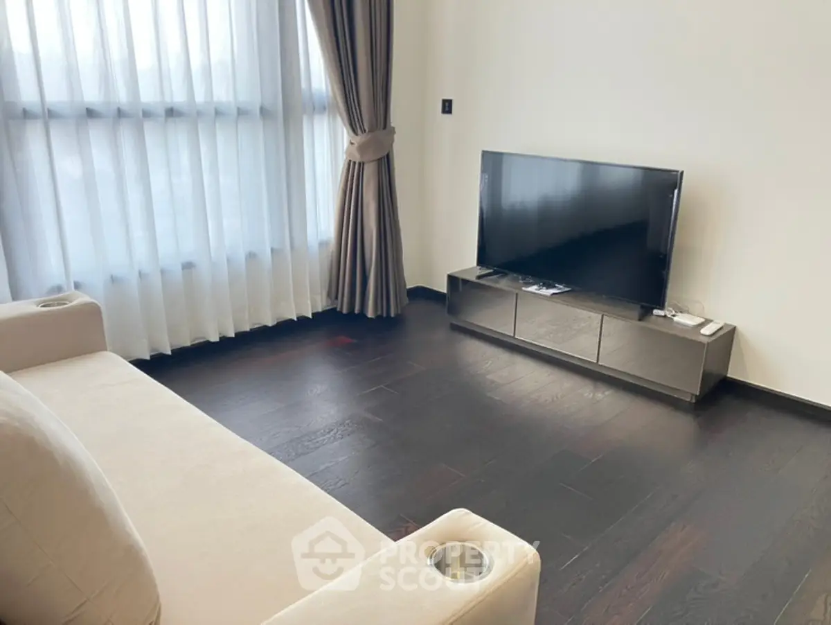 Modern living room with sleek TV setup and elegant curtains