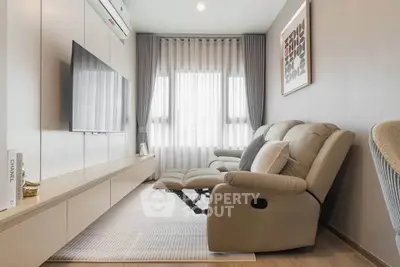 Modern living room with sleek furniture and large TV, perfect for relaxation and entertainment.