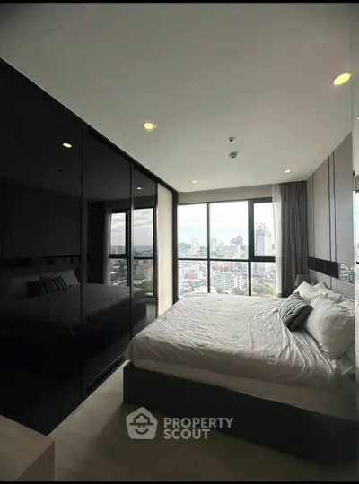 Modern bedroom with city view and sleek black wardrobe