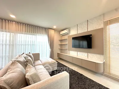 Modern living room with sleek sofa, wall-mounted TV, and elegant shelving