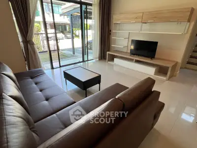 Modern living room with sleek furniture and large windows offering natural light.