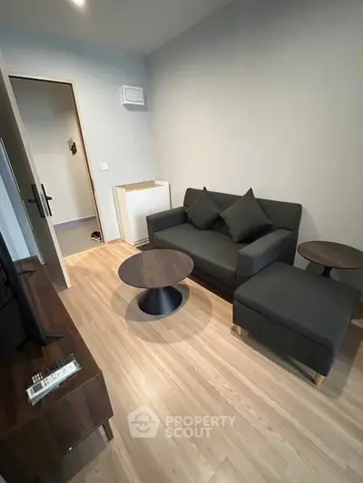 Modern living room with sleek furniture and wooden flooring in a cozy apartment.