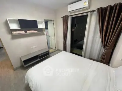 Modern bedroom with air conditioning and balcony access in a stylish apartment.